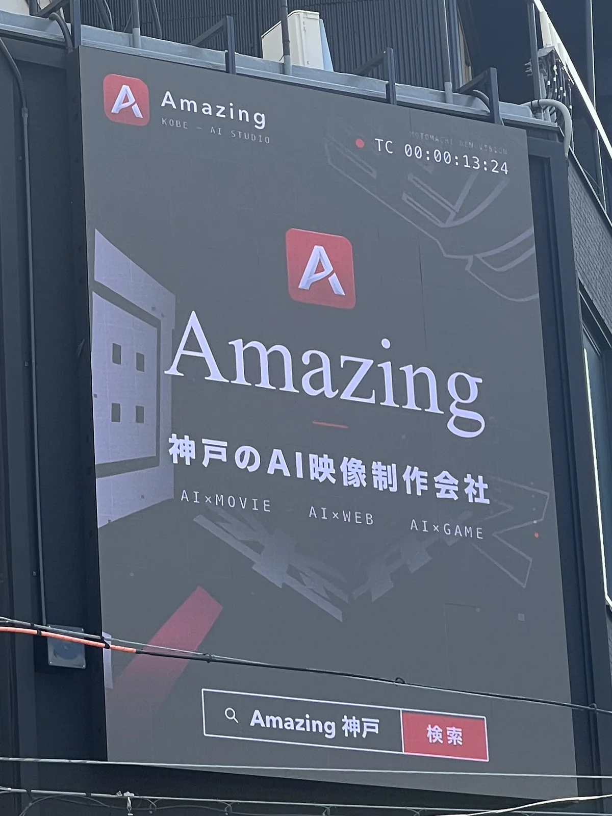 LEDビジョンの画面を寄りで捉えた写真。Amazingのロゴと「神戸のAI映像制作会社」の文字が映っている
